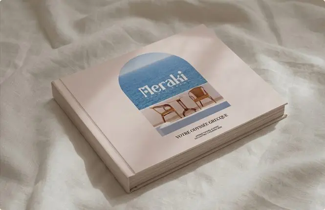 La plaquette Meraki « Votre odyssée grecque » posée sur un drap de lin.